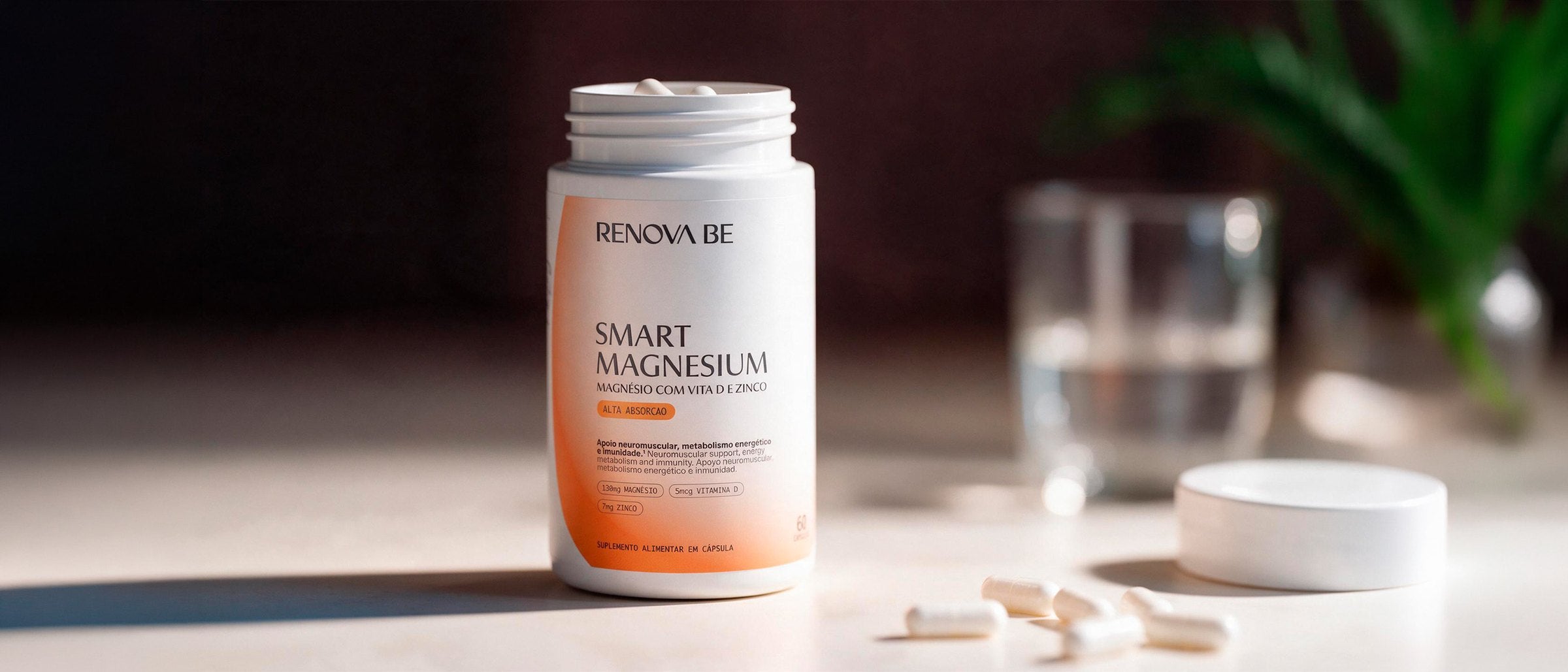 Pote do Smart Magnesium da Renova Be sobre a mesa, ao lado de um copo de água